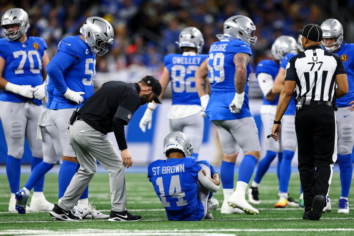 Amon-Ra St. Brown being attended to after suffering his ankle injury against the Packers.