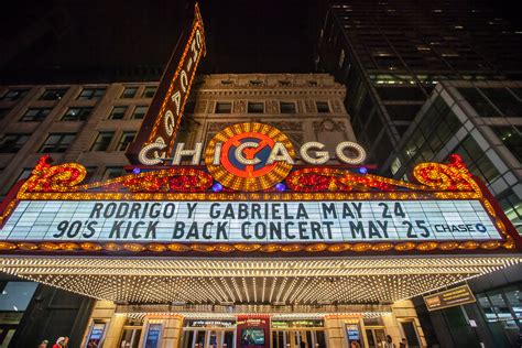 The Chicago Theatre marquee illuminated as police respond to nearby violence.