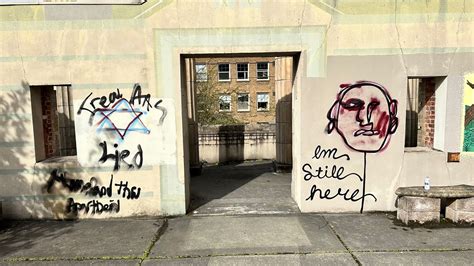 Vandalized swastika symbol on a public structure representing hate speech.