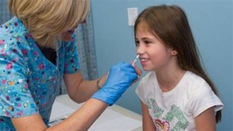 A child receives a flu shot from a healthcare provider.