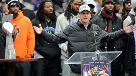 Harbaugh embraces players after leading the Ravens to Super Bowl victory.