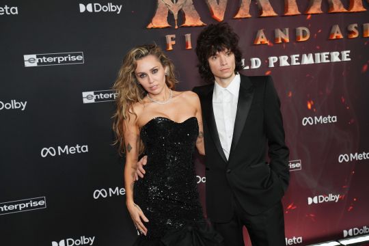 Miley Cyrus and Maxx Morando pose on the red carpet at the 'Avatar: Fire and Ash' premiere.
