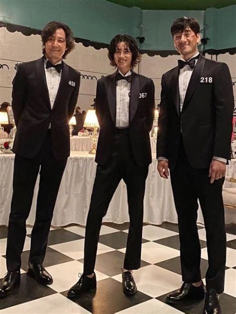 The five finalists of Squid Game: The Challenge Season 2, dressed in iconic black tuxedos, prepare for the final showdown.