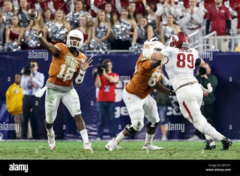 Texas defenders swarm Arkansas quarterback Taylen Green during their SEC matchup.
